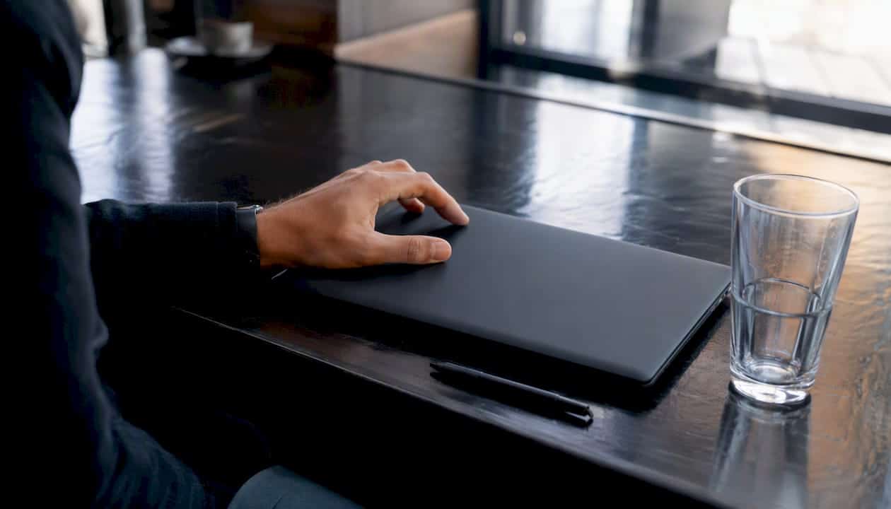Ένα κλειστό λάπτοπ και ένα στυλό πάνω στο γραφείο του γραφείου περιμένουν να ξαναχρησιμοποιηθούν.